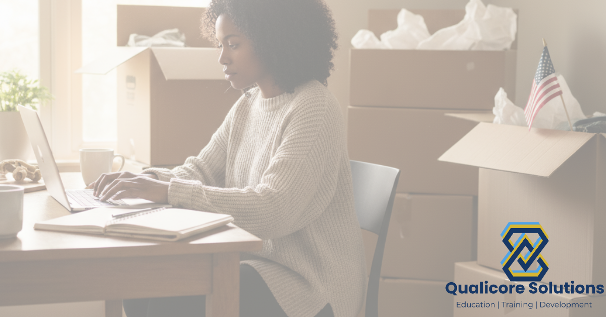 African American Woman typing on a laptop with moving boxes in the background
